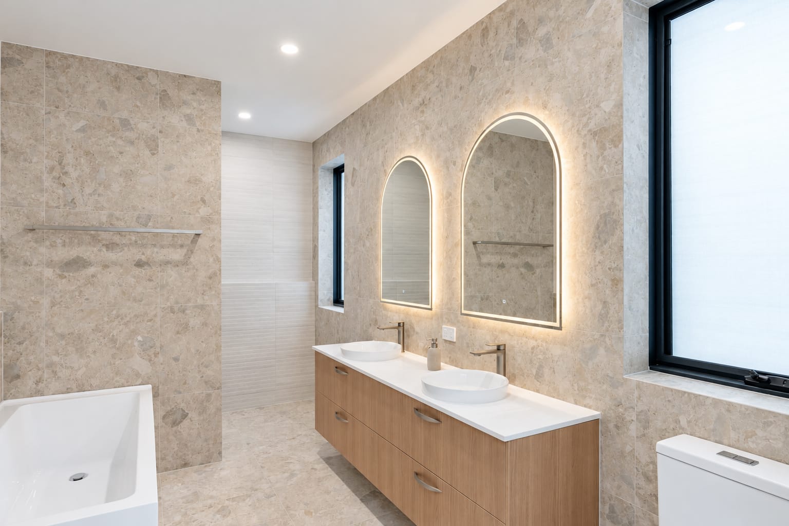 Finished bathroom with timber vanity and illuminated mirrors